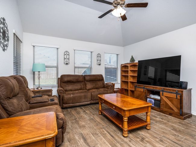 Living room featuring vaulted ceiling, ceiling fan, and wood finished floors | Image 15