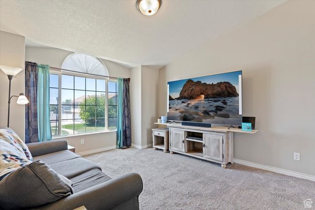 Living room featuring carpet floors, baseboards, and a vaulted ceiling | Image 7