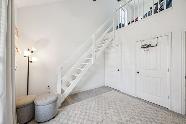 Stairway with carpet and a towering ceiling | Image 16