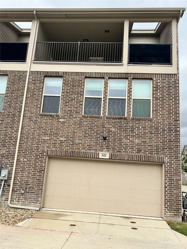 View of front of home featuring a garage, brick siding, and driveway | Image 27
