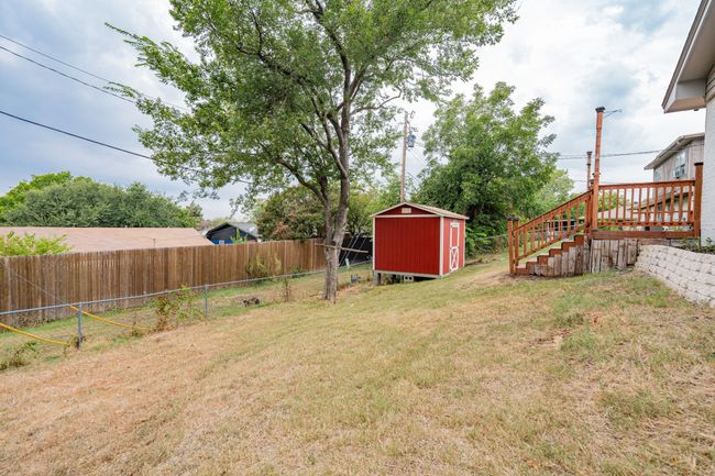 Fenced backyard featuring a storage shed and stairway | Image 27