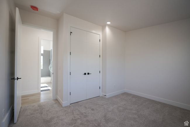 Unfurnished bedroom with carpet floors, a closet, baseboards, and recessed lighting | Image 16