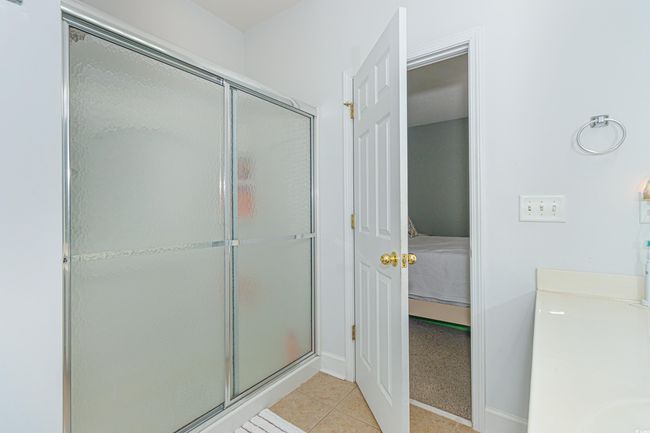 Bathroom with a shower with shower door and tile patterned floors | Image 19
