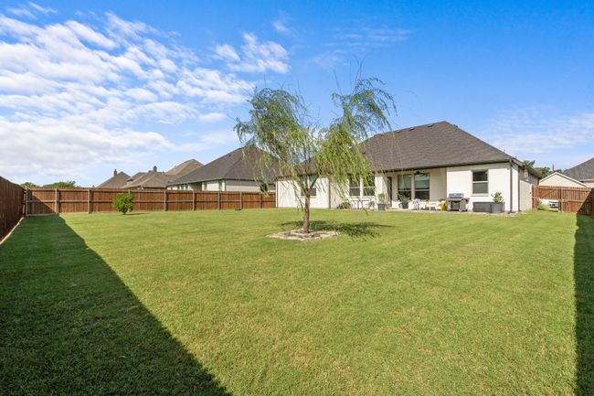 Fenced backyard with a patio area | Image 27