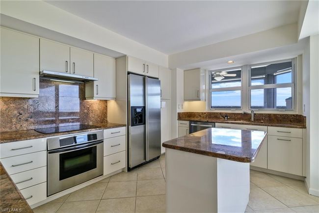 Kitchen with stainless steel appliances, a kitchen island. | Image 7