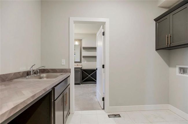 Laundry area featuring cabinet space, washer hookup, and baseboards | Image 14