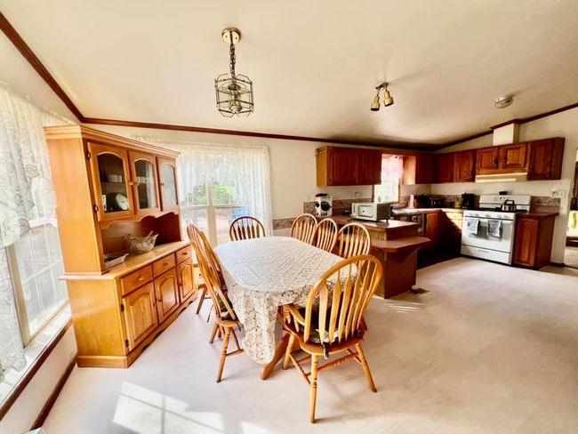 Dining area with light carpet, vaulted ceiling, a notable chandelier, and crown molding | Image 5