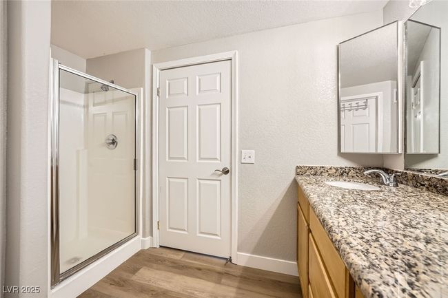 Full bathroom featuring baseboards, vanity, wood finished floors, and a shower stall | Image 17