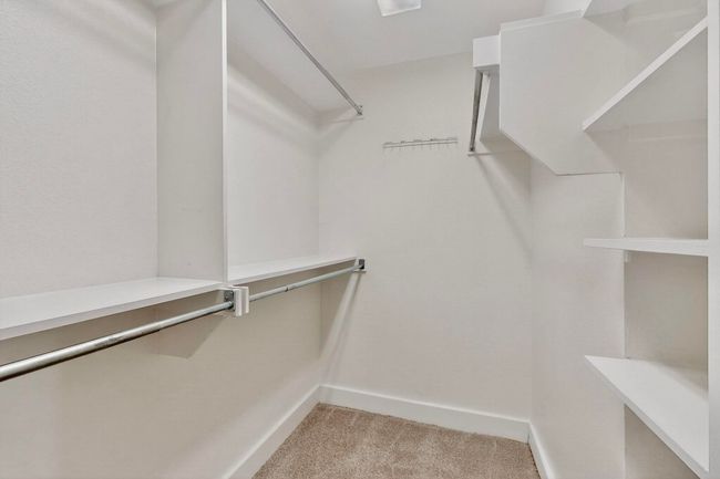 Walk in closet featuring light carpet | Image 23