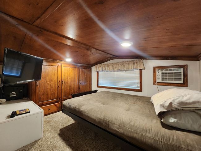 Private bedroom area of upper level of park model has built-ins and bed, etc. | Image 7