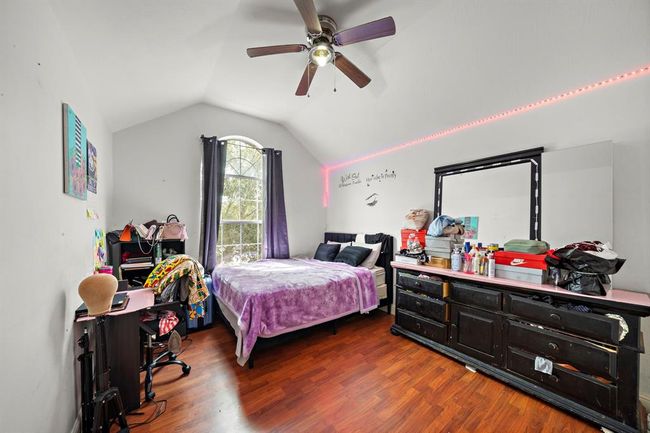This oversized secondary bedroom stands out with soaring vaulted ceilings and a dramatic arched window that fills the space with soft natural light. The spacious layout offers endless flexibility—perfect for a bedroom, study area, or creative space. | Image 23