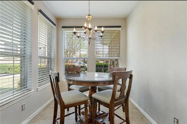 Dining area featuring an inviting chandelier and light tile flooring | Image 8