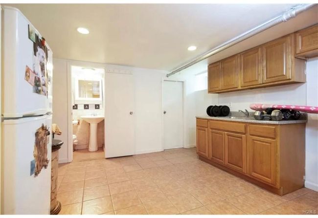 Kitchen with sink, white fridge, and light tile floors | Image 19
