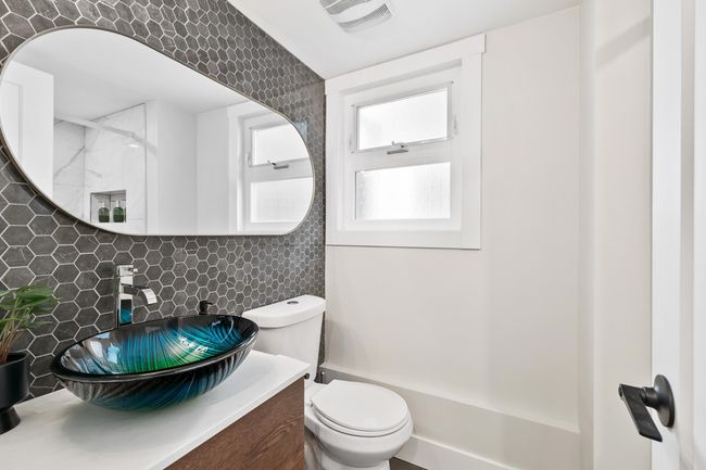 Bathroom featuring visible vents, toilet, backsplash, and vanity | Image 22