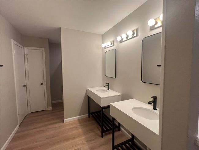Bathroom with wood finished floors, baseboards, and two vanities | Image 13