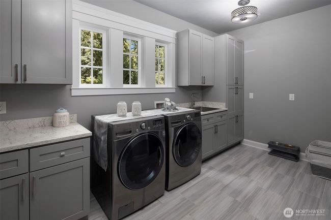 Main floor laundry with plenty of cabinet space. | Image 19