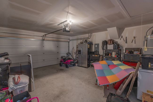 Garage with water heater, a garage door opener, and stainless steel fridge | Image 18