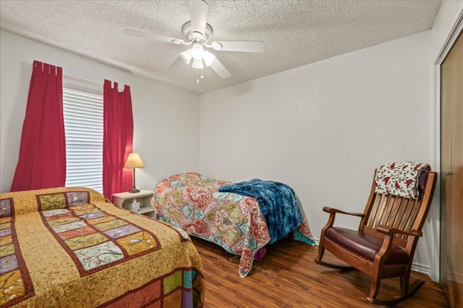 Bedroom featuring wood finished floors, a textured ceiling, and ceiling fan | Image 23