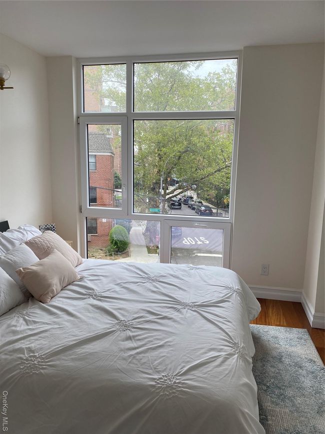 Bedroom with wood finished floors and multiple windows | Image 9