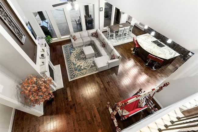 This upstairs view overlooks the living room, highlighting the stunning wall of windows that brings in abundant natural light and offers beautiful views of the outdoors. The open layout creates a sense of spaciousness, making the home feel bright and airy from every angle. | Image 40