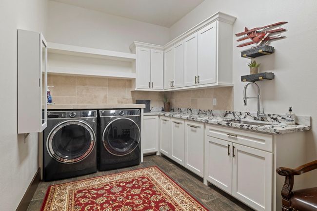 Laundry area with plenty of storage, built in ironing board. | Image 38