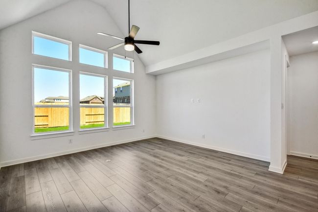 Unfurnished room with ceiling fan, dark wood finished floors, and high vaulted ceiling | Image 10