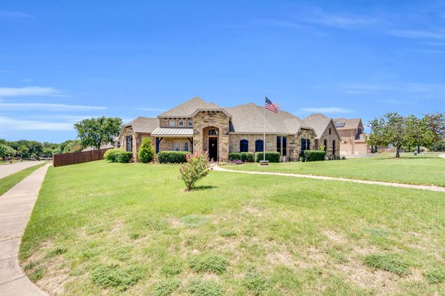 French country inspired facade with stone siding, brick siding, a standing seam roof, and a metal roof | Image 40