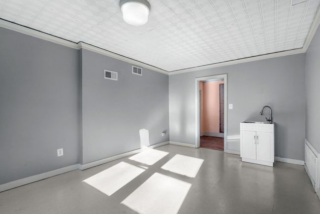 Empty room featuring baseboards, visible vents, a sink, and concrete floors | Image 24