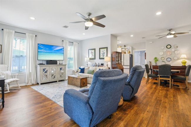 Living area featuring recessed lighting, a ceiling fan, and wood plank laminate flooring | Image 6