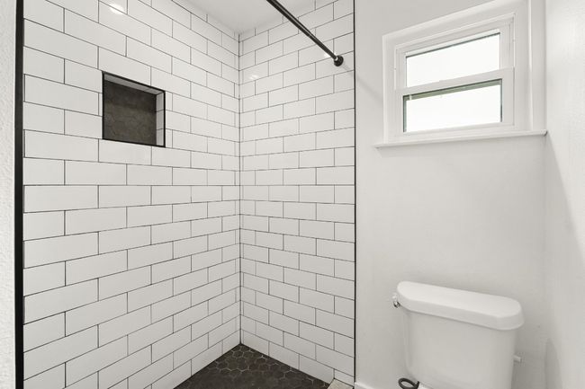 Bathroom with toilet and a tile shower | Image 15