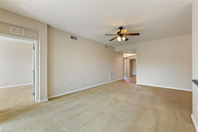 Spare room featuring a ceiling fan, carpet floors, and visible vents | Image 14
