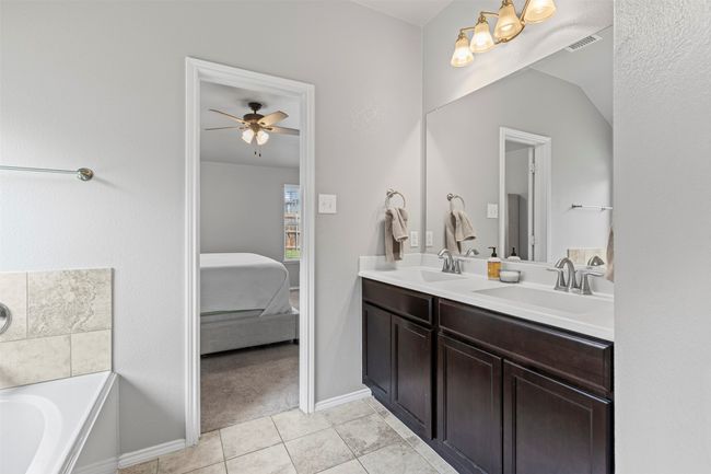 Ensuite bathroom with double vanity, ceiling fan, tile patterned flooring, and a garden tub | Image 17