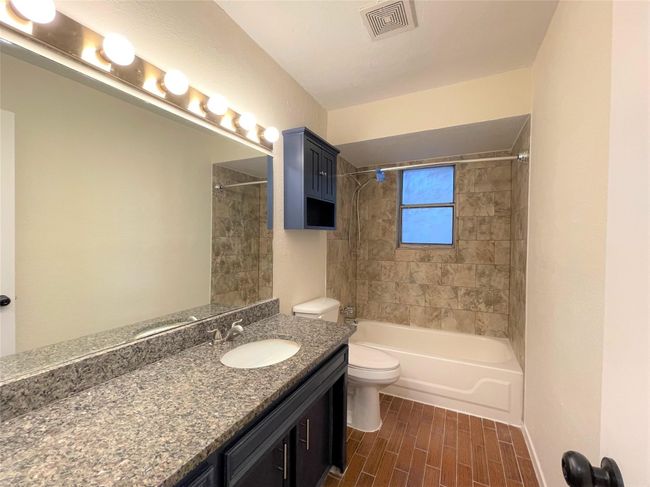 Full bath featuring vanity, shower / washtub combination, and wood finished floors | Image 19