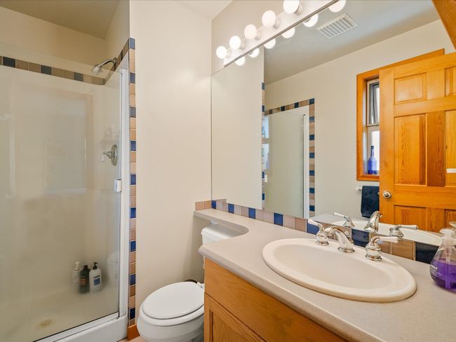 Full bath featuring visible vents, toilet, a shower stall, and vanity | Image 14