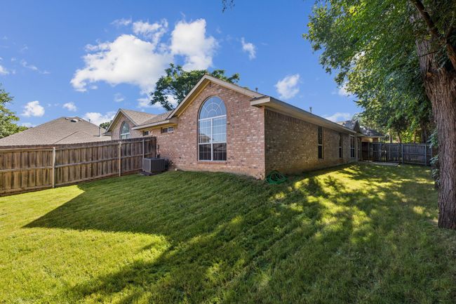 Rear view of property featuring brick siding and a fenced backyard | Image 26