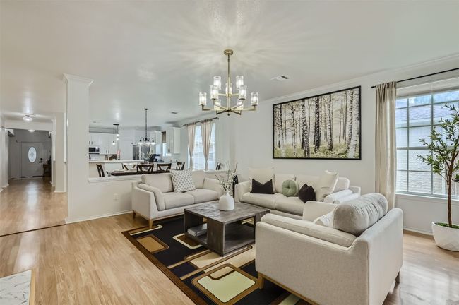 Living room with a chandelier and light wood-style floors | Image 5