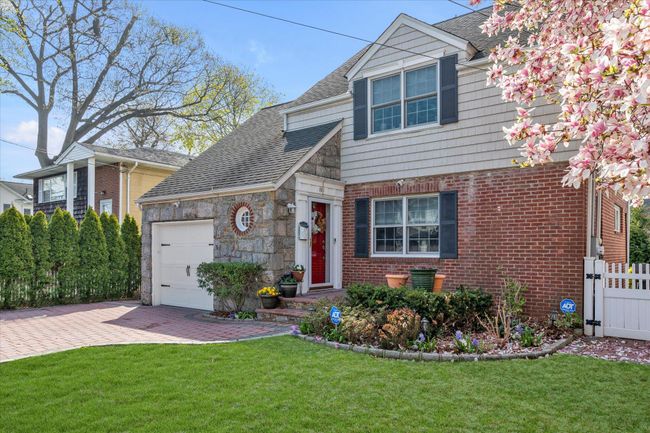 View of front of property featuring decorative driveway, a front lawn, fence, a garage, and roof with shingles | Image 18