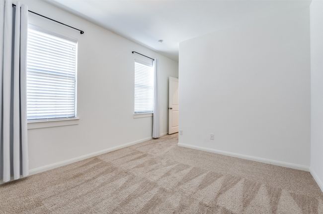 Third Bedroom - Bright and airy bedroom featuring soft, light-colored carpeting for a cozy feel, complemented by crisp baseboards that add a touch of elegance. The neutral palette offers a blank canvas, ready to be personalized to suit any style or need. | Image 28