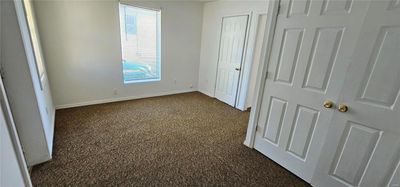 Unfurnished bedroom with dark carpet | Image 3