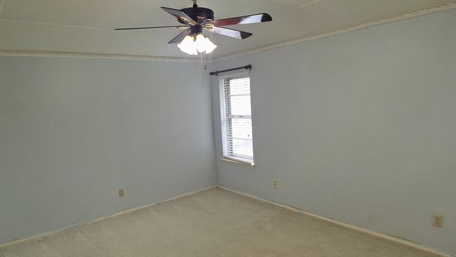 Unfurnished Primary Bedroom featuring a ceiling fan, light colored carpet, and ornamental molding | Image 17