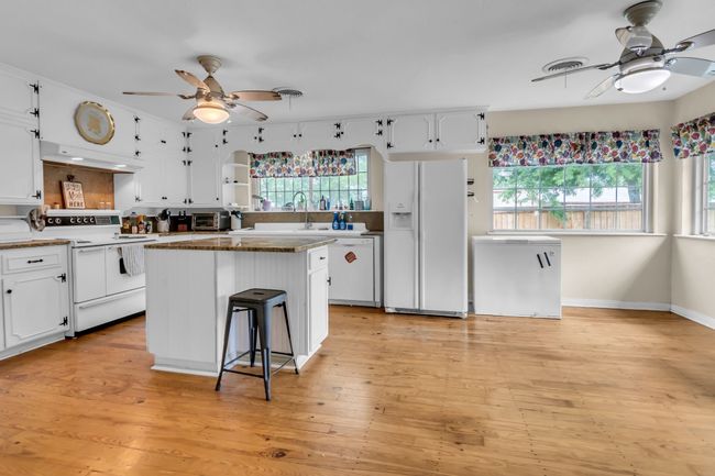 Kitchen with a ceiling fan, white appliances, and white cabinetry | Image 13