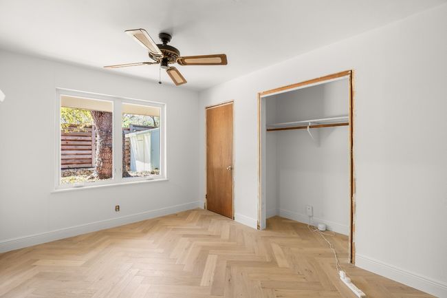 Unfurnished bedroom with ceiling fan, baseboards, and two closets | Image 28
