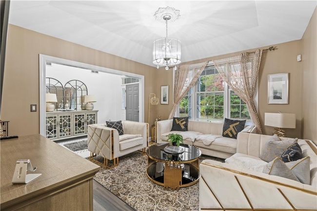 Living room featuring a chandelier and wood finished floors | Image 12