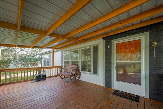 With a charming porch that invites you to relax on a cozy bench, perfect for enjoying the outdoors. | Image 6