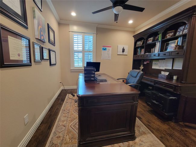Office space with dark wood-type flooring, a ceiling fan, ornamental molding, and recessed lighting | Image 14