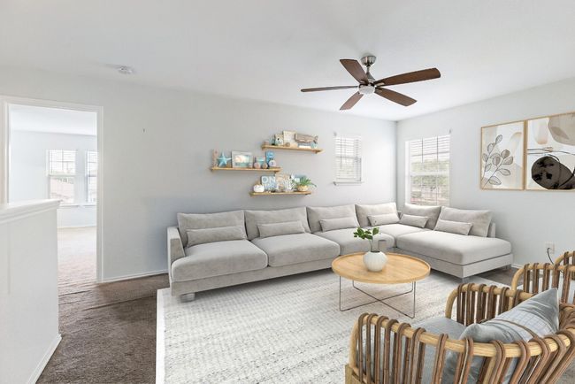 Carpeted living area with plenty of natural light, ceiling fan, and baseboards | Image 8