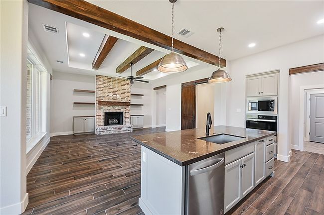 Kitchen with appliances with stainless steel finishes, a sink, dark wood finished floors, a ceiling fan, and beamed ceiling | Image 10