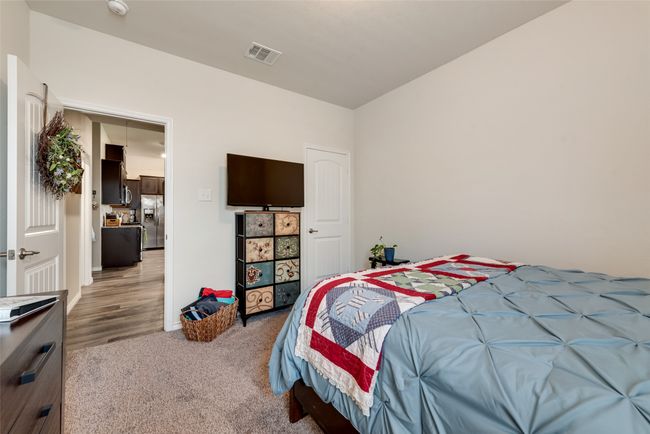 Bedroom with stainless steel fridge and light colored carpet | Image 24