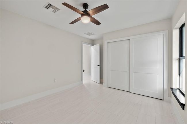 Unfurnished bedroom featuring a closet, light tile patterned floors, and ceiling fan | Image 33