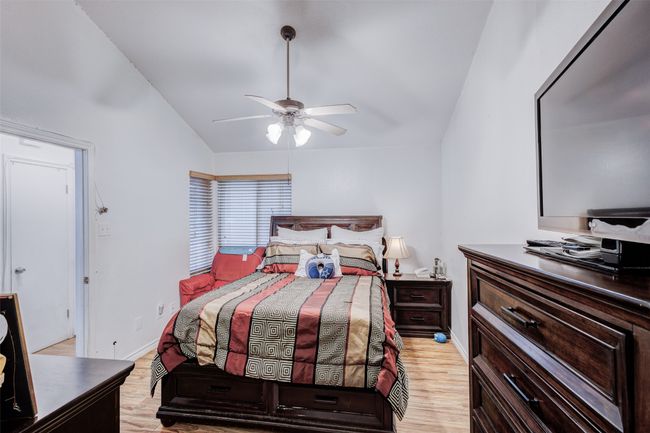 Bedroom with baseboards, lofted ceiling, ceiling fan, and light wood-style flooring | Image 19